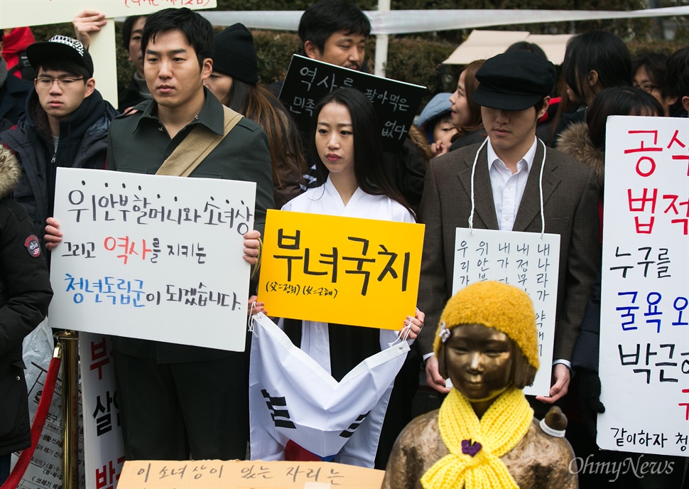  30일 오후 서울 종로구 일본대사관 앞에서 평화나비 네트워크 등 대학생들이 평화의 소녀상 비를 맞으며 주변 자리를 지키고 있다.