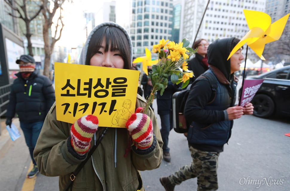"소녀상 지키기 위해 꽃 들고 나왔어요" 학생과 시민들이 9일 오후 서울 중구 서울시청광장에서 열린 일본군 위안부 한일합의 무효선언 국민대회를 마친 뒤 한일 위안부 문제 협상 폐기와 평화의 소녀상 이전 반대를 요구하며 거리행진을 벌이고 있다.