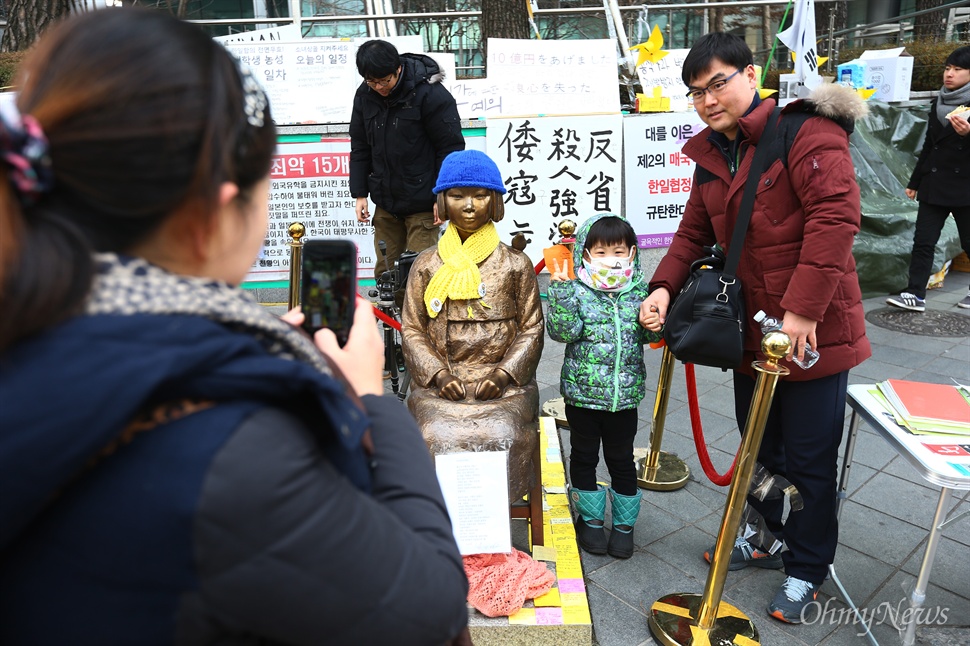  15일 오후 서울 종로구 일본대사관 앞 평화의 소녀상에 어린이들이 방문해 소녀상의 의미에 대해 설명을 듣고 함께 사진을 찍고 있다. 