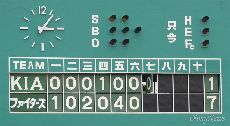  24일 오후 일본 오키나와 나고 야구장에서 열린 기아와 니혼햄와의 연습경기에서 경기장 관계자가 득점 상황을 알려주기 위해 수동으로 점수판을 고치고 있다.