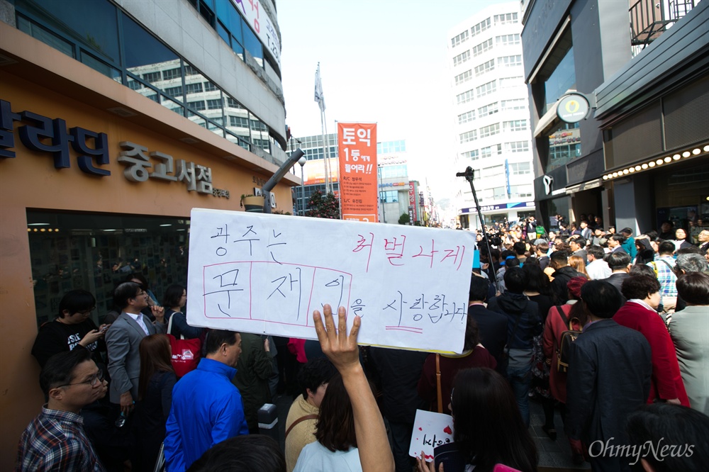  더불어민주당 문재인 전 대표가 8일 오후 광주 충장로 우체국 앞에서 '시민들에게 드리는 글'을 발표한 가운데, 한 시민이 문 전 대표를 지지하는 피켓을 들고 있다.