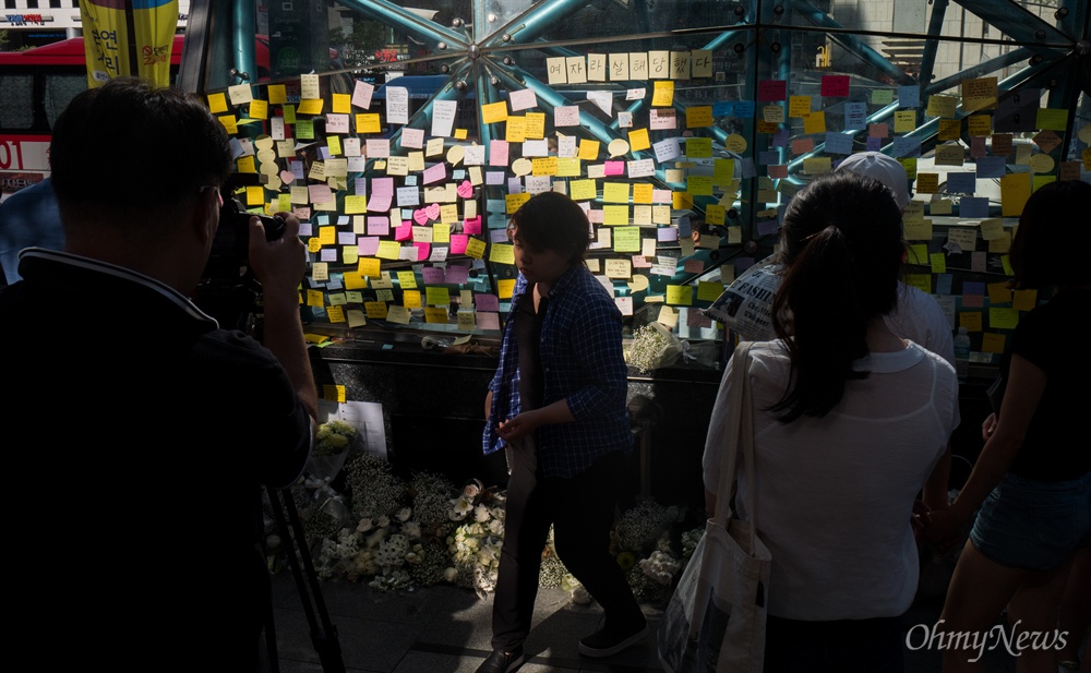  18일 오후 서울 강남역 10번 출구에는 지난 17일 새벽 노래방 화장실에서 발생한 '강남역 살인' 피해 여성을 추모하는 인파가 몰리고 있다. 추모를 위해 강남역을 찾은 시민들은 추모의 글을 적은 메모지를 붙히거나 헌화를 했다.