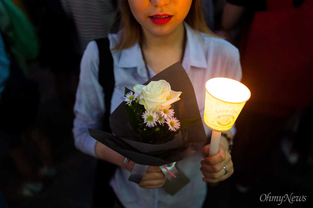 한 손엔 꽃, 한 손에 촛불 강남역여성살인사건이 발생한지 이틀이 지난 19일 오후 서울 강남역 10번 출구 인근에서 피해자를 추모하는 발길이 이어지고 있다. 