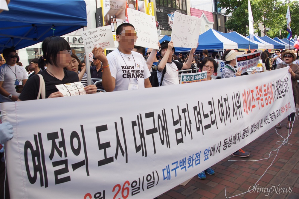  26일 오후 대구에서 열린 퀴어축제 무대행사장 옆에 보수기독교단체 회원들이 '예절의 도시 대구에 남자 며느리 여자 사위 에이즈 주범 동성애가 왠일입니까'라는 내용이 적힌 현수막을 들고 서 있다.