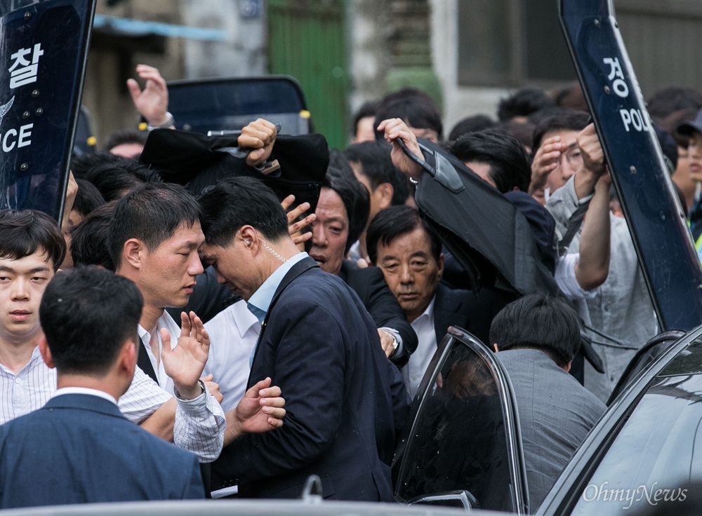 겁에 질린 한민구 국방부 장관 정부가 한반도 사드배치를 성주군으로 확정한 후 15일 경북 성주군청을 찾은 한민구 국방부장관이 사드배치를 설명하던 도중 성주군민들이 투척한 계란과 물병을 피해 버스에 고립돼 있다 군청을 빠져나가 던 중 주민들에게  가로막히자 경찰과 경호원의 보호를 받으며 차에서 내리고 있다. 