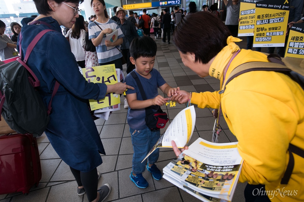 세월호유가족들이 13일 오전 서울역에서 추석을 맞아 귀성객을 향해 진상규명을 위한 피케팅과 노란리본을 나눠주고 있다.