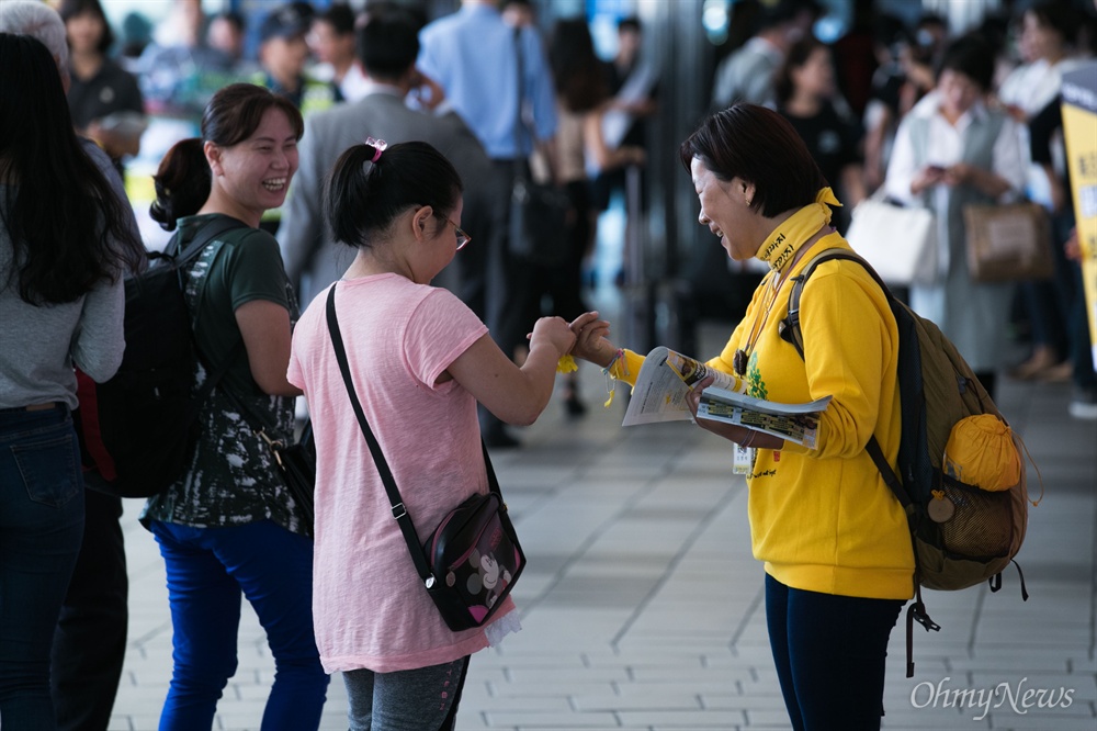  세월호 참사로 아들을 잃은 권미화씨가 13일 오전 서울역 대합실에서 귀성객에게 노란 기억리본을 나눠주며 인사하고 있다.