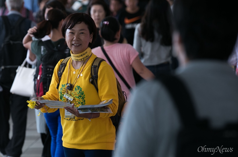  세월호 참사로 아들을 잃은 권미화씨가 13일 오전 서울역 대합실에서 귀성객에게 노란 기억리본을 나눠주고 있다.