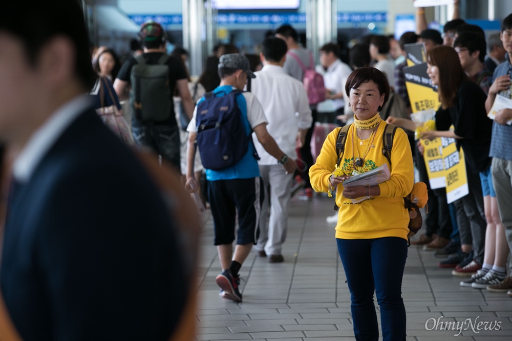  세월호 참사로 아들을 잃은 권미화씨가 13일 오전 서울역 대합실에서 귀성객들에게 노란 기억리본을 나눠주며 인사하고 있다.