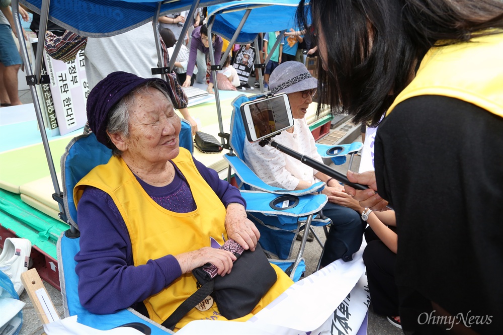 라이브 인터뷰에 응한 길원옥 할머니 추석 연휴 첫날인 14일 서울 중학동 옛 일본대사관 맞은편에서 열린 1248번째 수요시위에 일본군 위안부 피해자인 김복동·길원옥 할머니가 참여하고 있다. 윤미향 한국정신대문제대책협의회 상임대표(오른쪽)가 길원옥 할머니를 인터뷰하며 스마트폰으로 라이브방송을 내보내고 있다. 