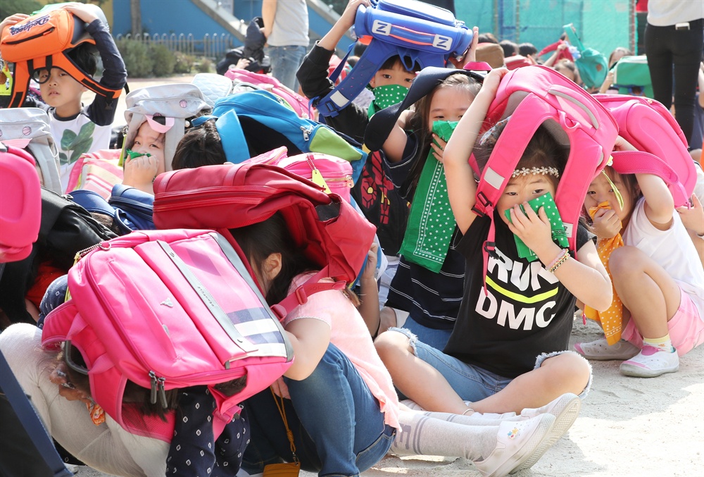 지진 대비 이젠 더 철저하게! 23일 오전 서울 강북구 송중초등학교에서 지진대피 훈련이 실시되고 있다. 지진경보가 울리자 학생들이 신속하게 가방으로 머리를 보호하며 대피하고 있다.