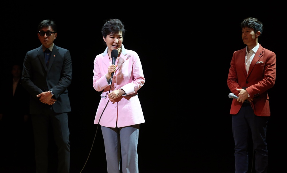  박근혜 대통령이 '문화가 있는 날' 행사의 일환으로 2014년 8월 27일 오후 서울 종로구 상명대학교 상명아트센터에서 열린 융복합 공연 '하루(One Day)'를 관람하기에 앞서 무대에 올라 인사말을 하고 있다. 왼쪽은 차은택 공연 총연출자, 오른쪽은 사회자 허경환. 이 공연은 견우와 직녀의 만남을 주제로 한 것이다.