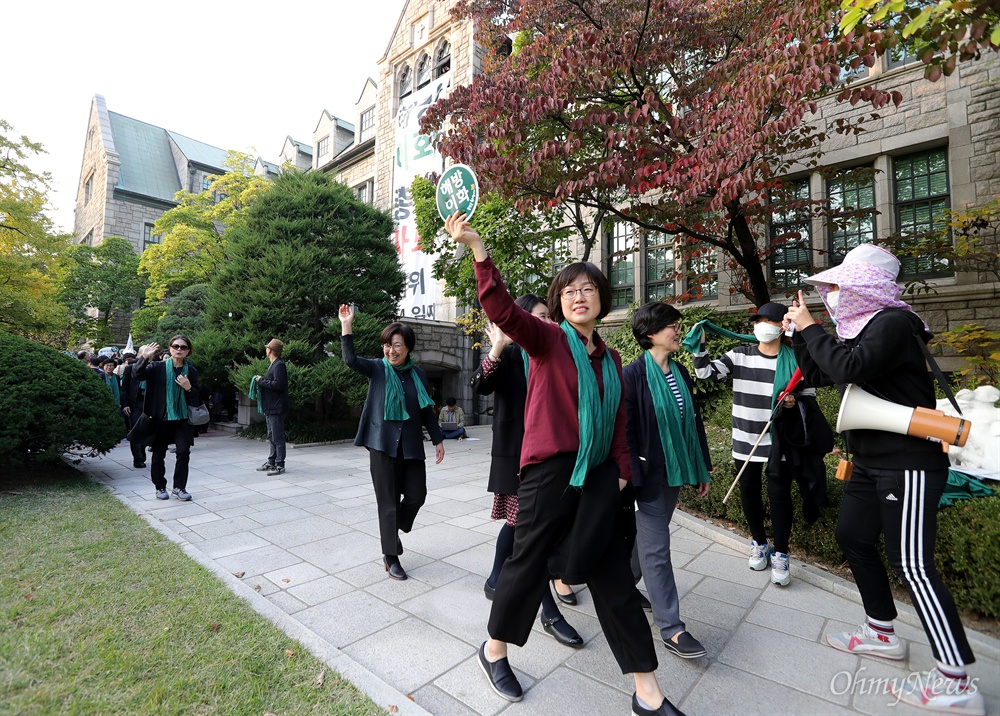 환호하는 학생 향해 손 흔드는 교수들 미래라이프대 설립과 '비선실세' 최순실 딸 부정입학 및 학사특혜 관련 논란으로 사퇴요구를 받아온 이화여대 최경희 총장이 19일 오후 교수들의 대규모 사퇴 촉구 기자회견 직전 전격 사퇴를 발표했다. 최 총장의 사퇴 발표에서 불구하고 교수들은 서대문구 이화여대 본관앞에 모여 예정된 기자회견을 열어 입장을 발표했다. 기자회견에는 80여일째 본관점거농성중인 학생들을 비롯해 수천명의 학생들이 참여해 교수들을 지지했다.