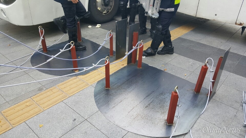  12일 광화문 일대에서 포착한 경찰 시위방어용품, 타이어 가림용 철판. 경찰들이 민중총궐기를 앞두고 경찰 차량을 보호하기 위한 장비를 설치하고 있다. 