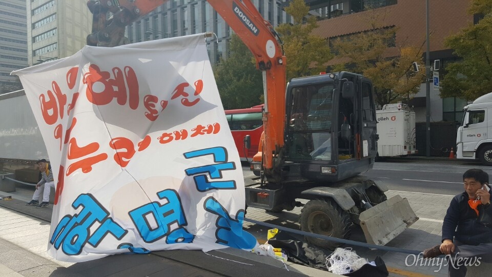  포크레인의 등장. '박근혜 퇴진 새누리당 해체 손가락혁명군'이라고 적힌 현수막을 달고 있다. 