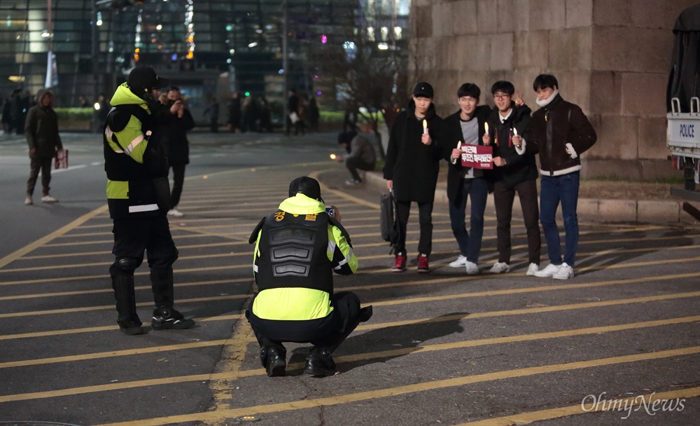 촛불시민 기념사진 찍어주는 시위진압경찰 3일 오후 광화문광장에서 열린 '박근혜 즉각퇴진의 날' 집회에 참석한 시민들 청와대 입구 동십자각 부근에서 경찰들에게 기념사진 촬영을 부탁했다. 시위 진압 복장을 한 경찰은 시민들의 연이은 요청에 선뜻 다양한 각도로 사진촬영을 해줬다.