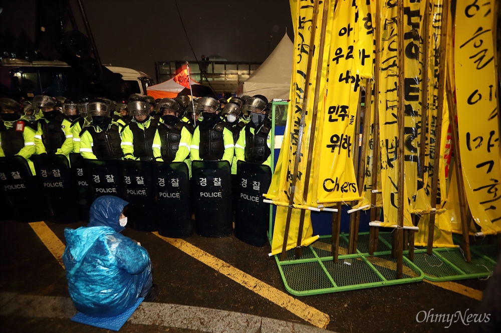 차벽에 막힌 국회 에워싸기 박근혜 대통령 탄핵안처리 하루전인 8일 오후 탄핵안 처리를 요구하는 시민들의 국회 에워싸기 행사가 경찰의 저지로 무산되었다. 시민들이 들고온 만장이 바리케이드에 놓여 있다.
