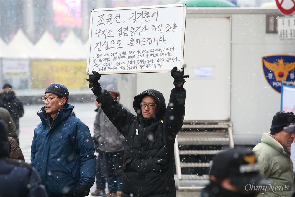 '김기춘 조윤선 구속 환영' ‘박근혜 즉각퇴진과 조기탄핵을 촉구하는 13차 범국민행동의 날’인 21일 오후 서울 광화문광장 부근에서 한 시민이 ‘문화계 블랙리스트’ 혐의로 이날 새벽 구속된 김기춘 전 대통령비서실장과 조윤선 문화체육관광부 장관의 구속을 환영하는 피켓을 들고 있다.