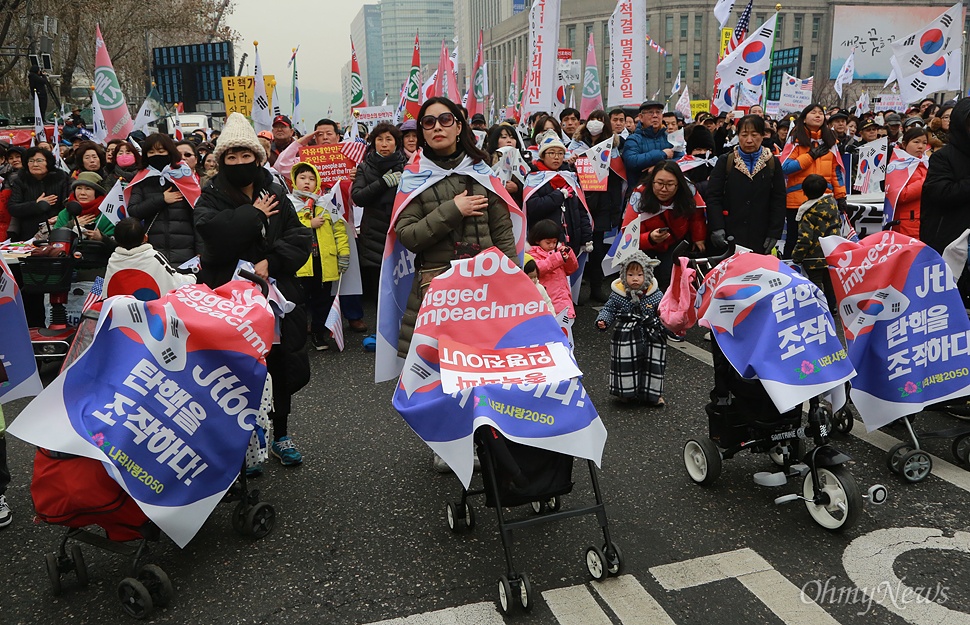 박근혜 탄핵 반대 집회, 국민의례하는 참가자들 4일 오후 서울 중구 덕수궁 대한문 앞에서 열린 '제11차 박근혜 대통령 탄핵기각을 위한 국민 총궐기 대회'에 유모차를 끌고 온 참가자와 시민이 국민의례를 하고 있다.