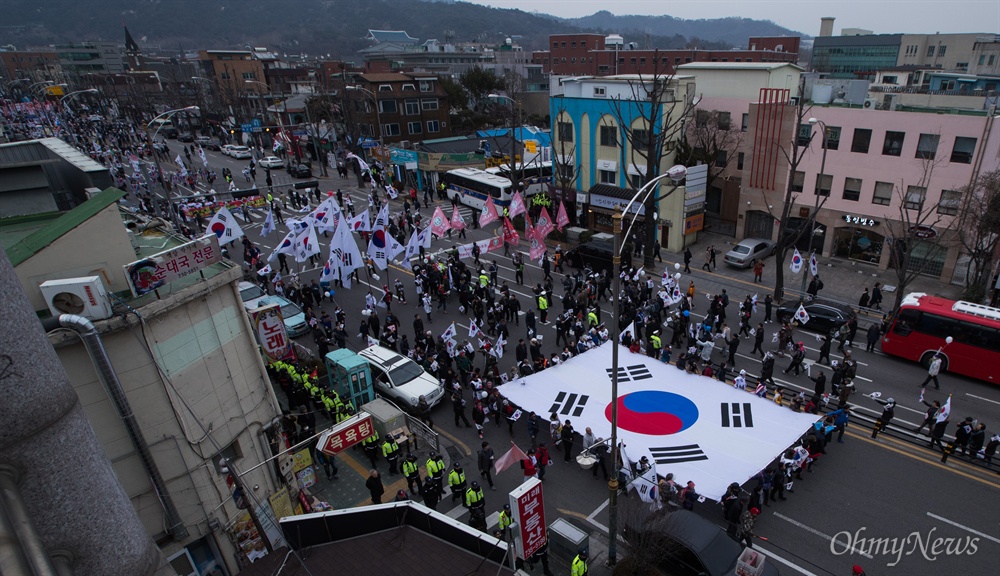   1일 오후 서울 종로구 정부서울청사 앞에서 애국단체총협의회 주최로 열린 탄핵기각 촉구 보수단체 집회에 참석자들이 청운효자주민센터를 향해 행진을 하고 있다.  
