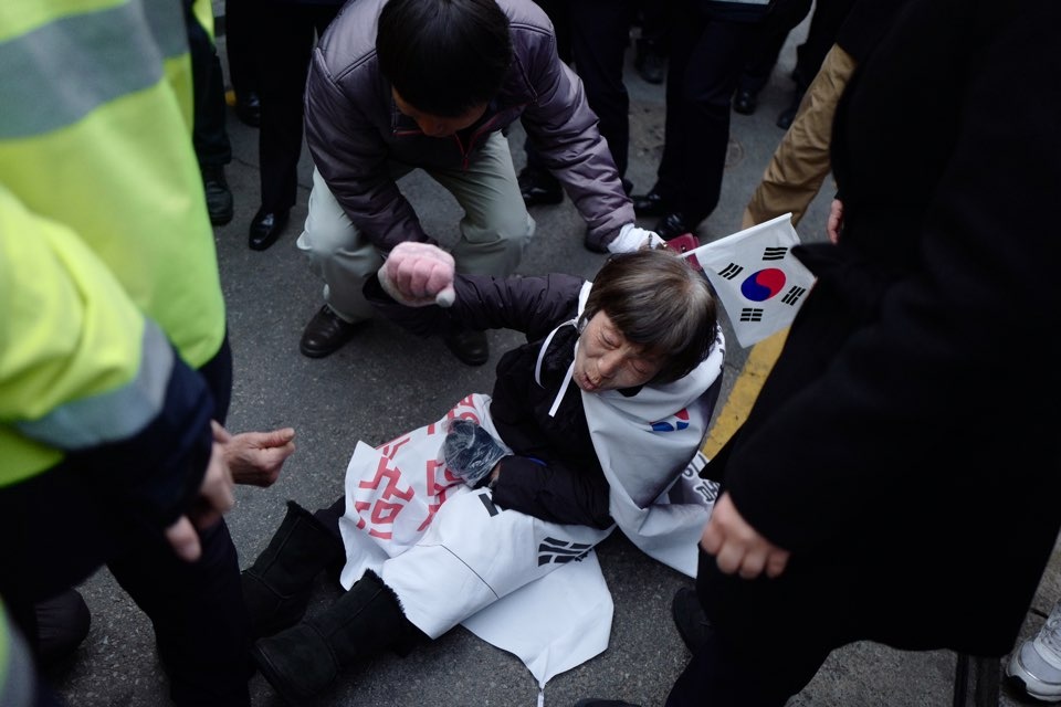  21일 오전 박근혜 전 대통령 자택 앞에 앉아 있던 지지자들이 경찰 병력에의해 끌려나온 후 바닥에 쓰러져 있다.