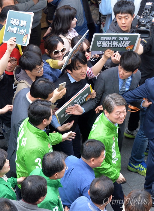  안철수 국민의당 제19대 대통령 후보가 20일 오후 서울 중구 남대문시장에서 상인들을 향해 유세를 펼치는 가운데 2017대선주권자행동 회원들이 안 후보를 향해 손피켓을 들고 항의하고 있다.
