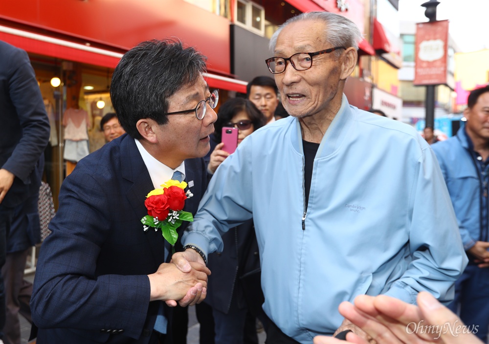 유승민에게 꽃 선물한 90대 노인  바른정당 유승민 대선후보가 24일 오후 강원도 춘천 명동을 방문해 꽃을 건낸 한 시민과 인사를 나누고 있다. 