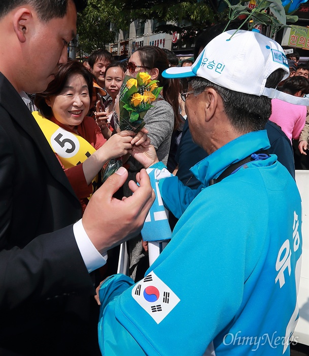 '고마워요 심상정' 심상정 정의당 후보가 29일 오후 경기도 성남 모란시장에서 유세를 하는 가운데, 유승민 바른정당 후보 선거운동원이 심 후보에게 꽃을 선물하고 ‘굳세어라 유승민’이 적힌 피켓을 들고 함께 기념촬영을 하고 있다. 심상정 후보는 지난 25일 JTBC TV토론에서 후보사퇴 압력을 받고 있는 유승민 후보를 향해 ‘굳세어라 유승민’을 외치며 ‘낡은 수구보수에 맞서 보수의 가치를 지켜달라’며 응원을 했다.