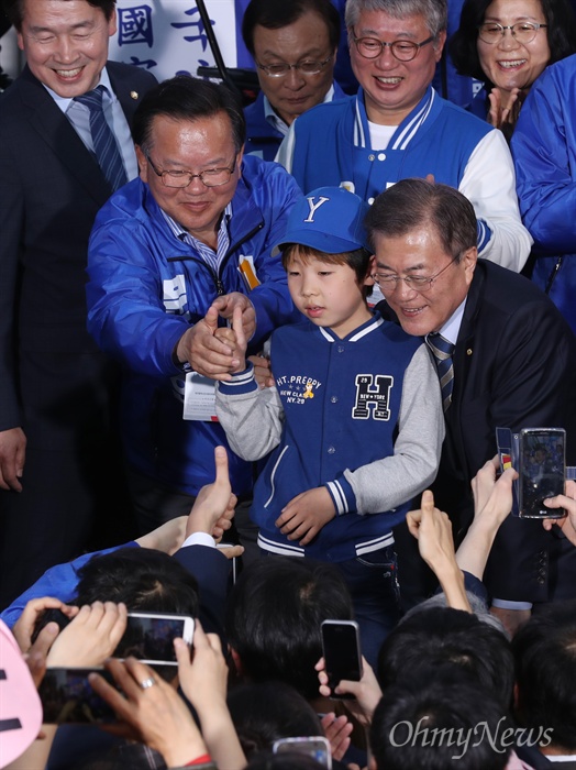 임무완수 29일 오후 광주 충장로 우체국 앞에서 열린 문재인 더불어민주당 대선후보 집중유세에서 문 후보와 인증샷을 남기던 한 어린이가 손가락 두 개(기호2번)를 펴 'V'자를 그리자, 김부겸 공동선대위원장이 황급히 손을 가져다 대 손가락 한 개(기호1번)로 고쳐주고 있다.