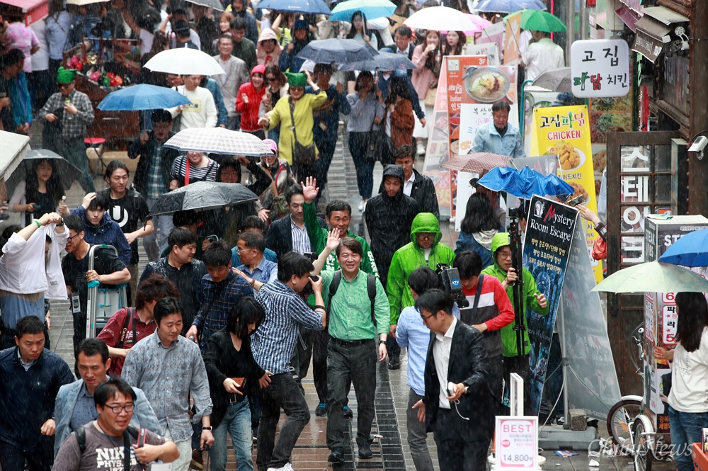  국민의당 안철수 대선후보가 5일 오후 부산 남포동 BIFF(부산국제영화제) 거리에서 갑자기 내린 소나기를 맞으며 도보 유세를 펼치고 있다.