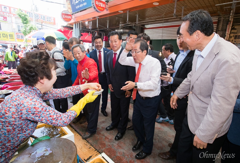 "해삼 묵고 가이소" 자유한국당 홍준표 후보가 7일 오후 경남 창원 마산어시장을 방문해 상인이 주는 해삼을 먹고 인사를 하고 있다. 