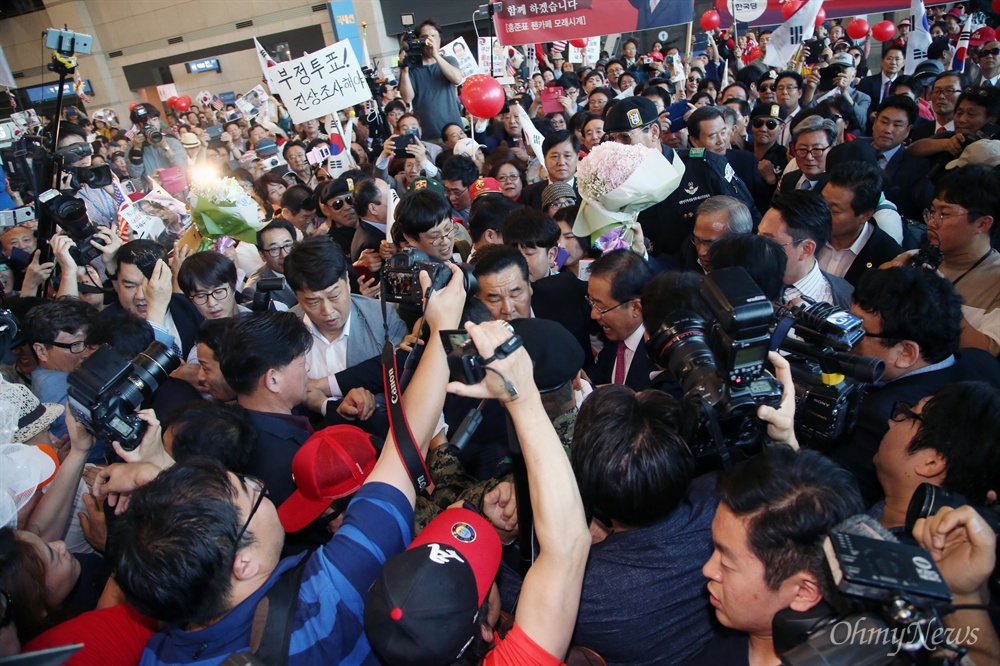 '레드준표'를 찾아라! 대선 패배 후 미국으로 출국했던 홍준표 자유한국당 전 대선 후보가 4일 오후 인천공항에 도착해, 지지자들에 둘러싸인 채 입국장을 나서고 있다. 