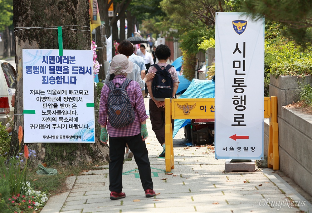 청와대 입구 농성장 안내문 투쟁사업장 공동투쟁위 소속 노동자들이 청와대 분수대 입구 인도에서 농성중인 가운데, ‘통행에 불편을 드려 죄송’하다는 공동투쟁위의 안내문과 ‘시민통행로’ 경찰안내문이 함께 놓여 있다.