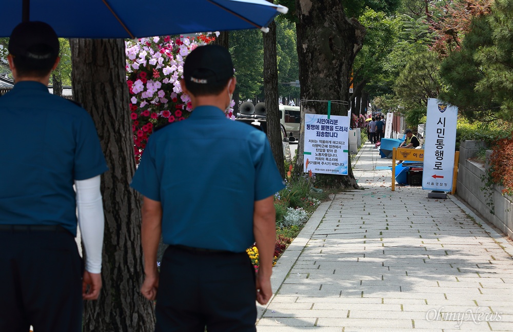 청와대 입구 농성장 안내문 투쟁사업장 공동투쟁위 소속 노동자들이 청와대 분수대 입구 인도에서 농성중인 가운데, ‘통행에 불편을 드려 죄송’하다는 공동투쟁위의 안내문과 ‘시민통행로’ 경찰안내문이 함께 놓여 있다.