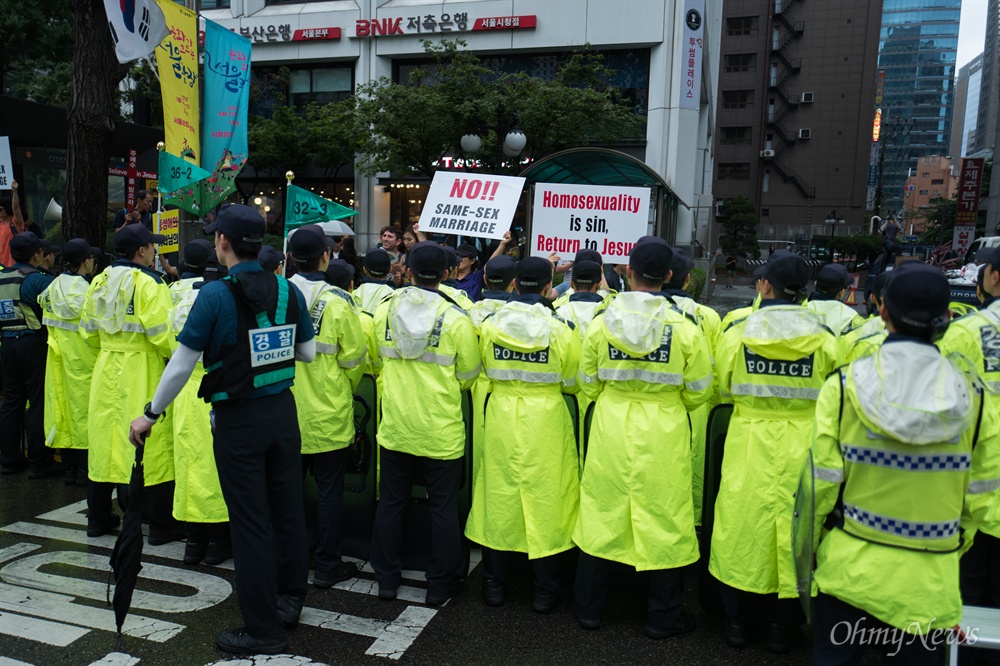  15일 오전 서울 시청 앞 서울광장에서 열린 제 18회 퀴어문화축제에서 무대행사가 끝난 직후 진행된 퍼레이드 행렬 옆으로 반대 시위를 하고 있다.