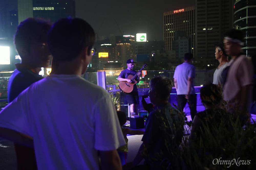  6일 오후 서울 중구 만리동과 퇴계로를 잇는 ‘서울로 7017’에서 찾은 시민들이 기타리스트 김세형씨의 멋진 연주를 들으며 즐거운 시간을 보내고 있다.