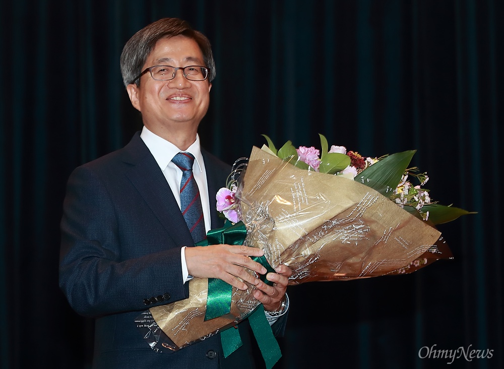 축하 꽃다발 받은 김명수 대법원장 김명수 대법원장이 26일 오후 서울 서초구 대법원 대강당에서 열린 취임식에서 축하 꽃다발을 받아들고 있다.