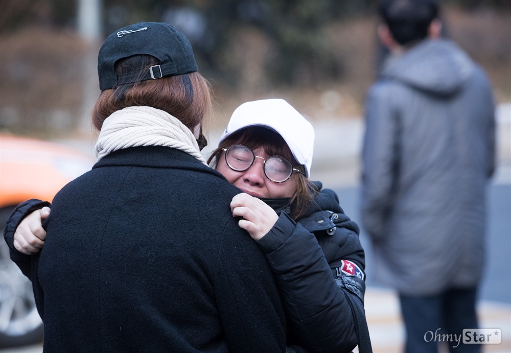  21일 오전 서울 강동구 서울아산병원에서 샤이니 멤버 고 종현의 발인이 끝나자 한 팬이 주저 앉아 울고 있다.