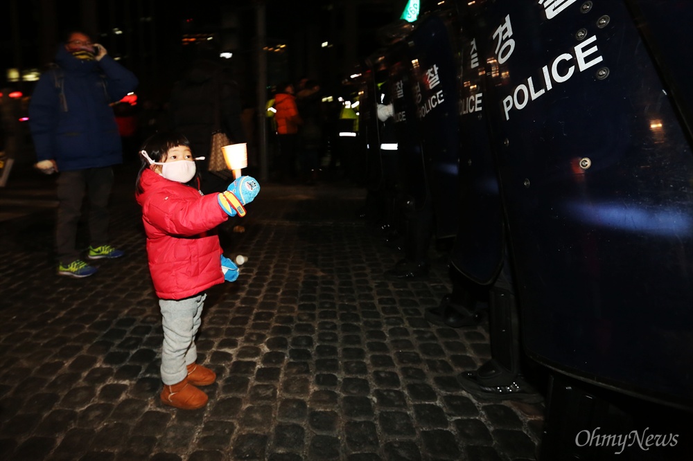 촛불 든 어린이  28일 서울광장 앞에서 민주노총 총파업을 참가했던 참가자들이 청계천으로 이동하던 중 길을 막고 있던 경찰 앞에 한 어린이가 촛불을 들어 보이고 있다.