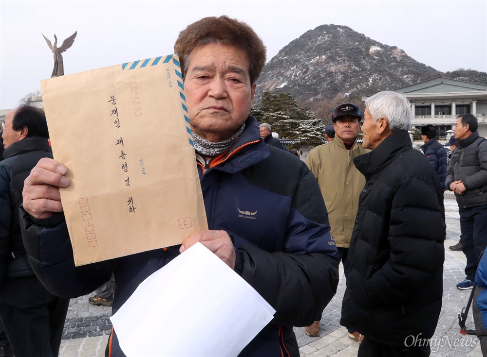 서산개척단이 문 대통령에 보내는 서한  서산개척단 정영철씨가 31일 오후 청와대 앞에서 기자회견을 열고 박정희판 군함도 서산개척단의 진실을 문재인 정부가 밝혀주길 호소하며 문 대통령에 보내는 서한을 들어보이고 있다.  