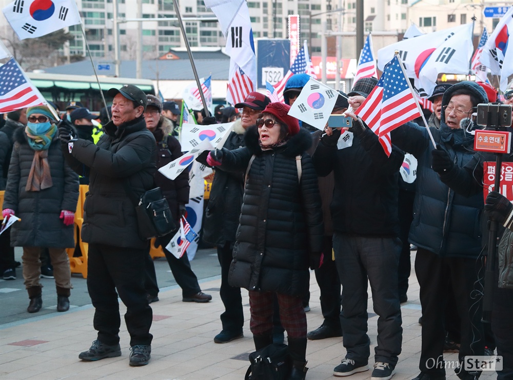 김일성-김정일-김정은 사진태우는 보수단체 현송월 삼지연관현악단장이 이끄는 북측 예술단 첫 공연이 8일 오후 강원도 강릉 아트센터에서 열릴 예정인 가운데, 보수단체 회원들이 공연장 인근에 모여 태극기와 성조기를 흔들며 '평양올림픽' 이라고 주장하며 시위를 벌이고 있다. 참석자들이 김일성, 김정일, 김정은, 인공기가 그려진 종이를 불 태우고 있다.