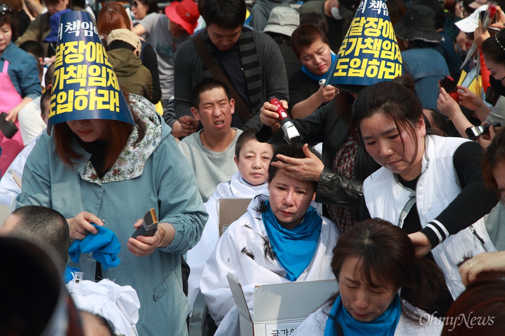 장애인부모 200여명 눈물의 삭발식 “국가가 발달장애인 지원하라” ‘세계 자폐증 인식의 날’인 2일 오후 서울 종로구 청와대 연무관 앞에서 장애 자녀를 둔 부모들이 발달장애인 국가책임제 도입을 촉구하며 삭발을 하고 있다.