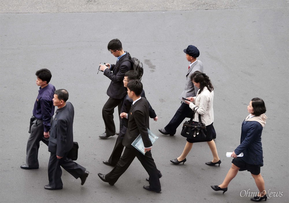 평양시민도 스마트폰 삼매경 3일 오전 평양 주민들이 출근하는 가운데, 일부는 스마트폰을 들여다보며 걷고 있다.