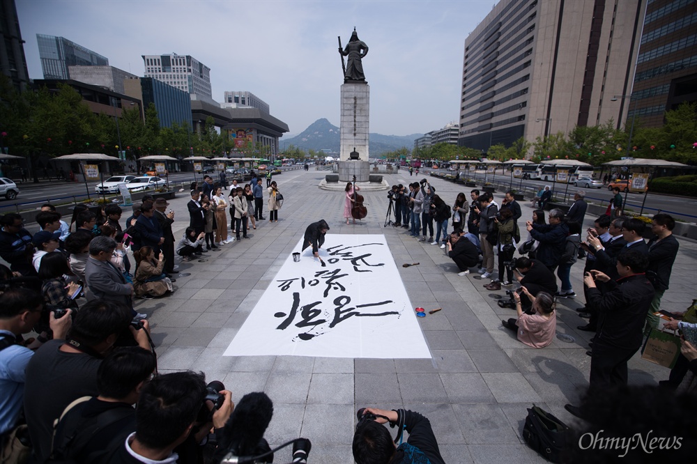  캘리그라피스트 강병인 작가가 26일 오후 서울 광화문 광장에서 남북정상회담 성공을 기원 하는 대형 붓글씨를 쓰고 있다.