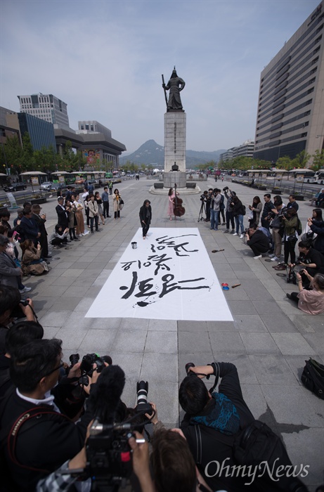  캘리그라피스트 강병인 작가가 26일 오후 서울 광화문 광장에서 남북정상회담 성공을 기원 하는 대형 붓글씨를 쓰고 있다.