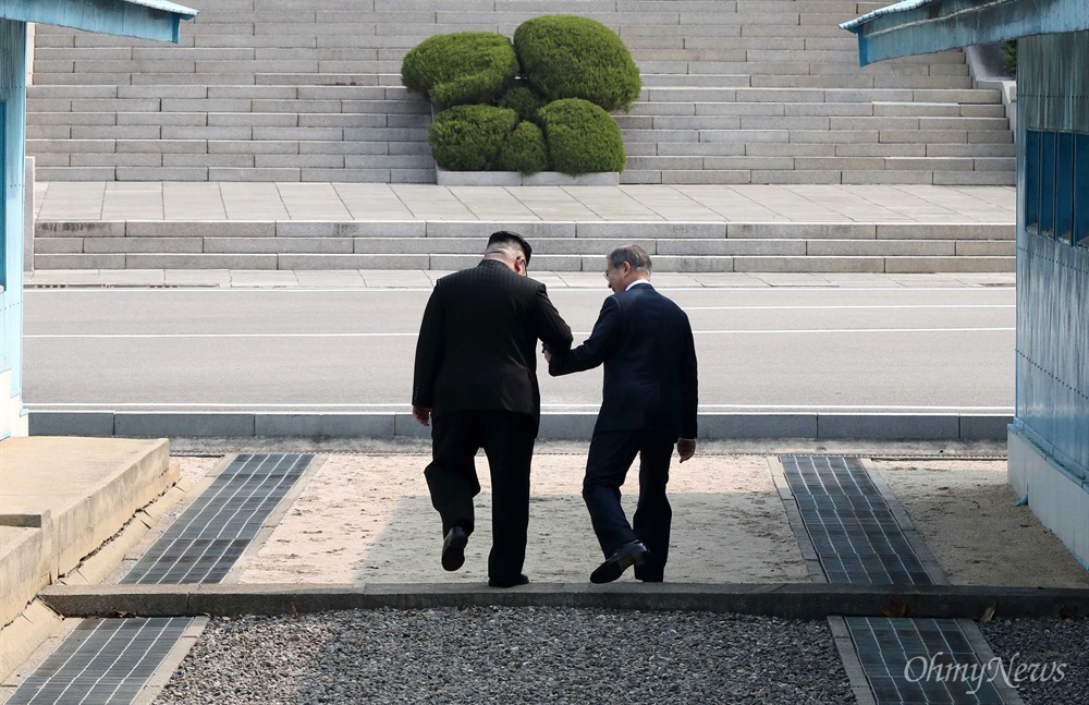 군사분계선 넘는 남-북 정상 2018 남북정상회담이 열린 27일 오전 문재인 대통령과 김정은 국무위원장이 판문점에서 만난 뒤 손을 잡고 함께 군사분계선을 넘고 있다.