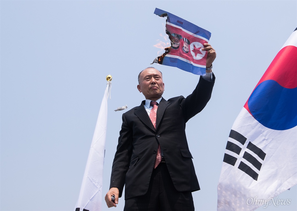  남북정상회담이 열리는 27일 오후 경기도 파주 임진각 인근에서 한 보수단체 회원들이 정상회담 반대 시위를 하던 중 김정은 삼부자가 인쇄 된 인공기를 불태우고 있다.