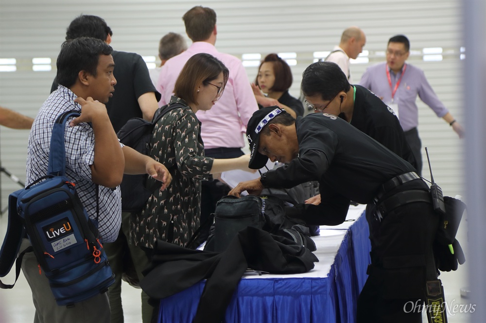소지품 검색 받는 취재기자들 사상 첫 북미정상회담을 이틀 앞둔 10일 오전 싱가포르 마리나베이 포뮬러원(F1) 경기장 건물에 마련된 미디어센터에서 경호원들이 외부인의 출입을 통제하며 소지품을 검사하고 있다.