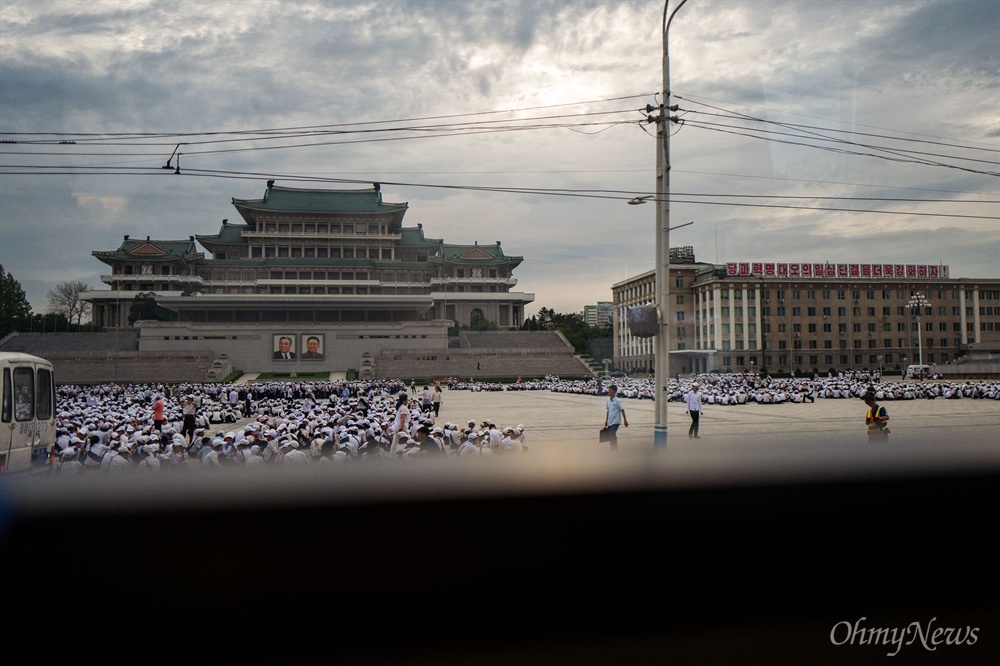  4일 오전 평양 김일성광장에서 주민들과 학생들이 흰색 모자를 쓰고 한자리에 모여 있다.