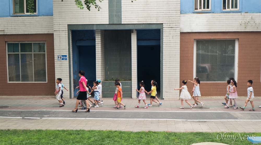  6일 오전 평양 시내에서 탁아소(어린이집)에 맡겨진 어린이들이 선생님과 친구들과 함께 길을 걷고 있다. 